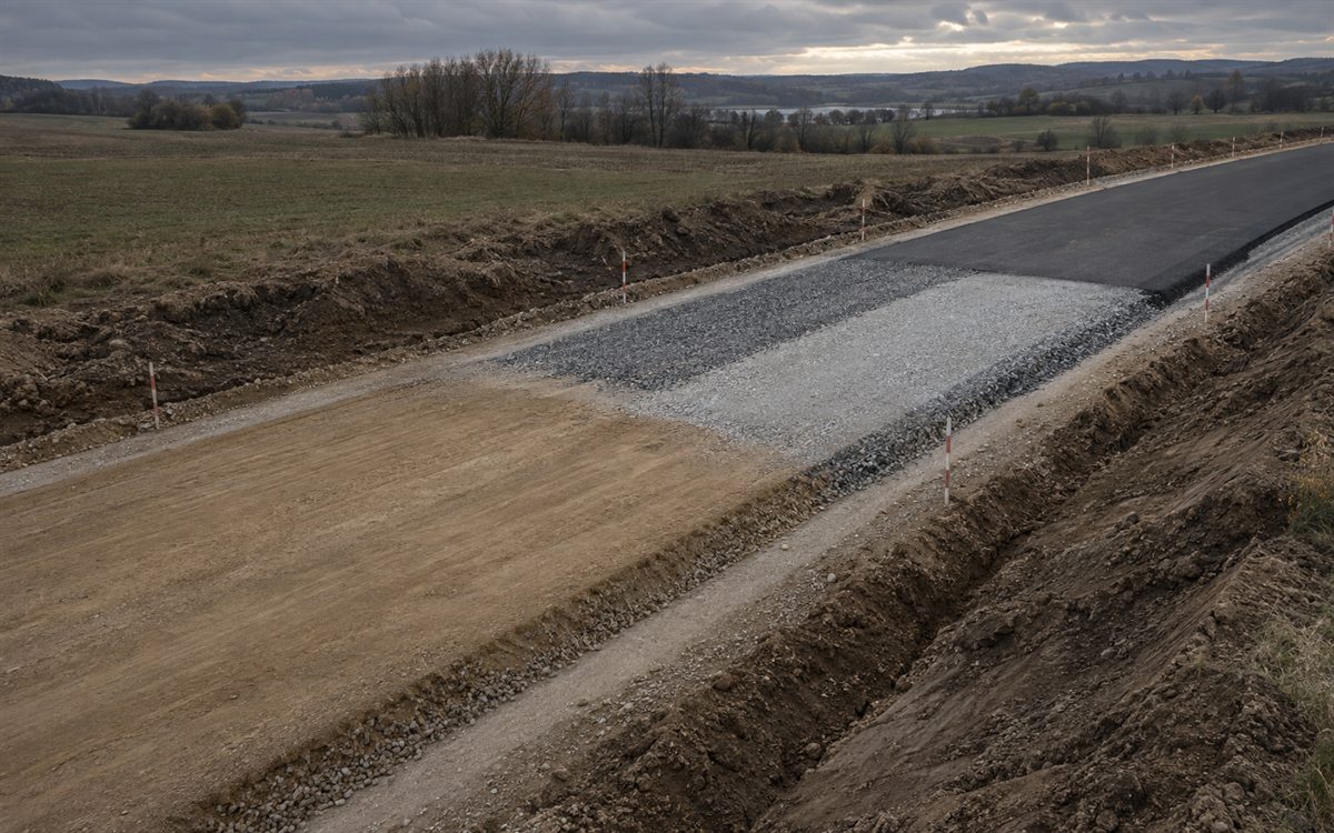 Отдельный участок дороги в работе: земляное полотно и слои дорожной одежды, вид сверху